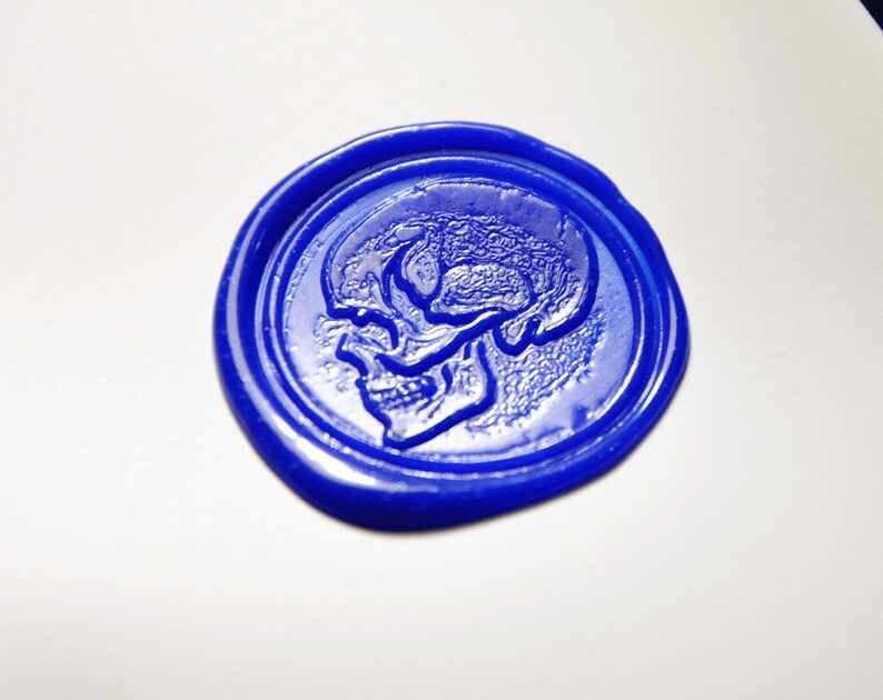 Op de afbeelding: Een blauwe waszegel met een reli&euml;f van een schedel.