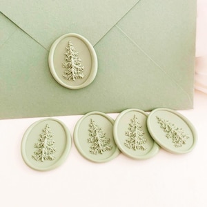 May include: Sage green wax seals with an embossed fir tree design. The seals are oval-shaped and are displayed on a sage green envelope. The seals are a decorative element for stationery, invitations, or crafts.