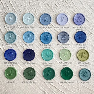 May include: A collection of twenty wax seals in various colors, including light blue, baby blue, and green. Each seal is round with a cursive "R" design. The colors are labeled with numbers and names, such as "#41-Light Blue" and "#50-Teal".