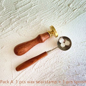 May include: A wax seal stamp with a wooden handle and a brass seal head, next to a small metal spoon holding three white wax beads. The text "Pack A: 1 pcs wax seal stamp + 1 pcs spoon" is at the bottom.