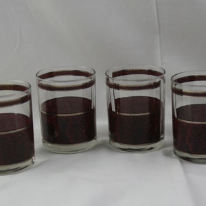 May include: Set of four clear glass tumblers with a red and gold geometric pattern.