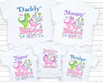 May include: A set of four white t-shirts with dinosaur graphics and text that reads "Daddy of the Birthday Girl", "Mommy of the Birthday Girl", "Sister of the Birthday Girl", and "Brother of the Birthday Girl". One shirt also includes the text "Birthday Girl 3 Amelia".