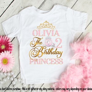 May include: White t-shirt with a gold crown, pink carriage, and the text "OLIVIA The 2 Birthday PRINCESS".