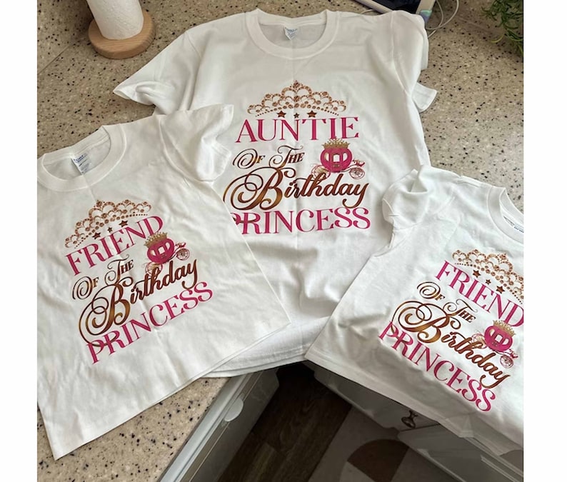 Pu&ograve; includere: Tre magliette bianche con testo rosa e dorato. Le magliette dicono "Zia della principessa del compleanno", "Amico della principessa del compleanno" e "Amico della principessa del compleanno".