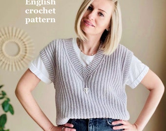 May include: A woman wearing a light purple crochet vest over a white t-shirt and dark blue jeans. The vest has a V-neck and is crocheted in a simple stitch. The text "English crochet pattern" is visible in the top left corner of the image.