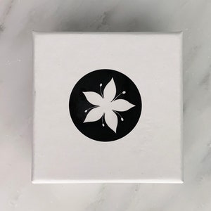 The Tigerlilly jewelry box, with a white lily flower on a black circle logo