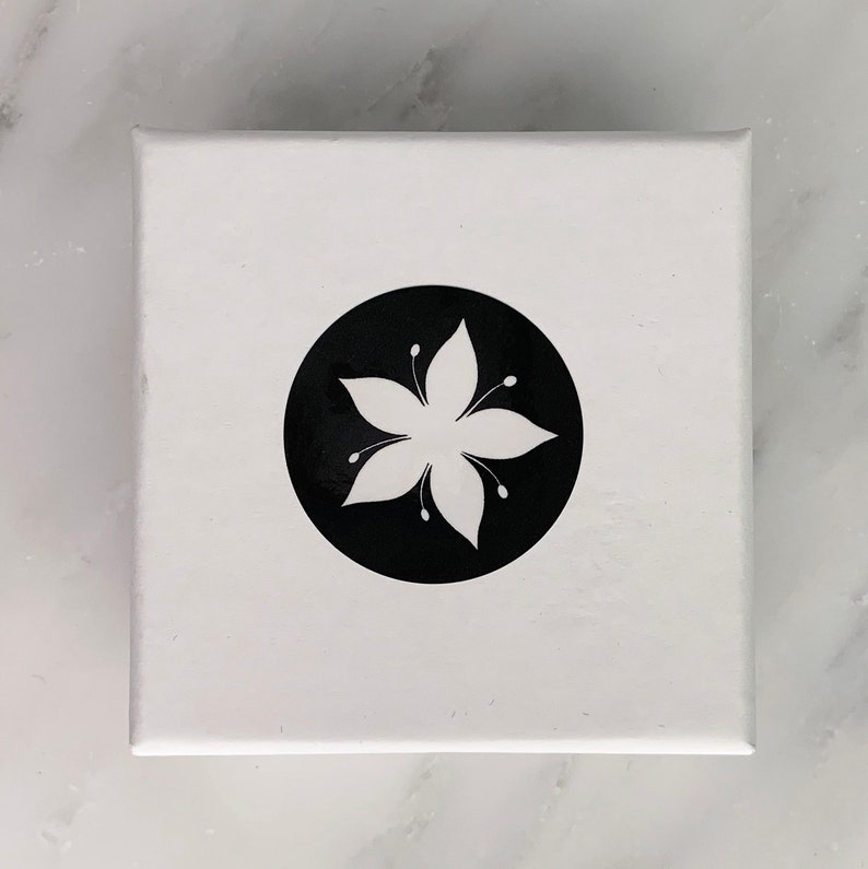 The Tigerlilly jewelry box, with a white lily flower on a black circle logo