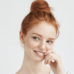 Model wearing crescent moon stud earrings