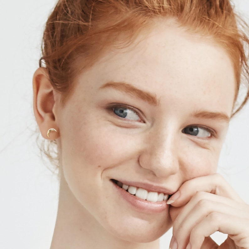 Model wearing crescent moon earrings in gold