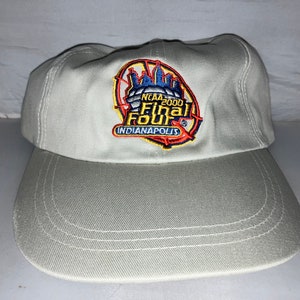 May include: A light gray baseball cap with an embroidered patch that says "NCAA 2000 Final Four Indianapolis".