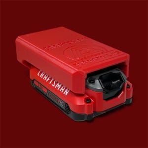 May include: A red Craftsman 20V battery with a red cover. The Craftsman logo is visible in white on the battery and the cover. The cover also has the text "Craftsman" and "3D Moto Lab".