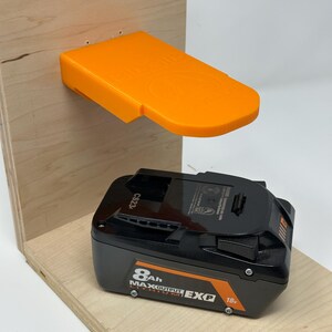 Wall mount battery holder compatible with Ridgid 18V batteries, 3D-printed organizer for workshop or garage. Durable 3D-printed wall mount for Ridgid 18V power tool batteries, easy-install storage bracket. Ridgid 18V battery wall holder and organizer, heavy-duty plastic mount for secure tool battery storage. Compact Orange wall-mounted rack designed to hold Ridgid 18V lithium power tool batteries. Space-saving Ridgid 18Vbattery mount for workshop walls, keeps batteries organized.