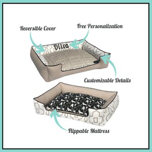 May include: A beige dog bed with a reversible cover and flippable mattress. One side features a beige and white geometric pattern, the other a beige and white pattern with the name "Oliva". The mattress has a black and white dog pattern.