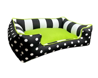 May include: A black and white polka dot dog bed with a green stripe and a green center cushion.