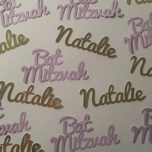 May include: Purple and gold paper cutouts with the text "Bat Mitzvah" and "Natalie".