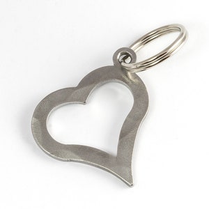 May include: A silver heart-shaped keychain with a metal ring.