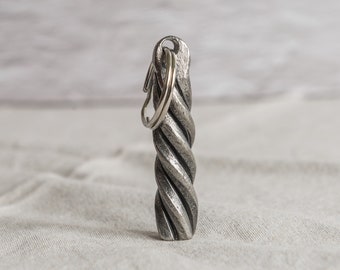 May include: A silver metal keychain with a twisted design and a silver key ring.