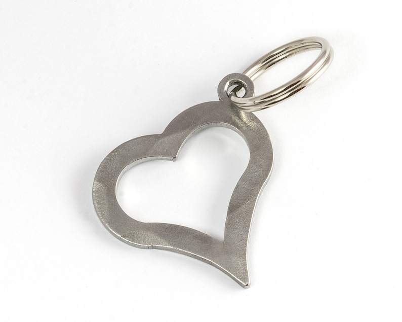 May include: A silver heart-shaped keychain with a metal ring.