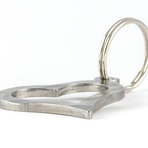 May include: A silver heart-shaped key chain with a double ring.