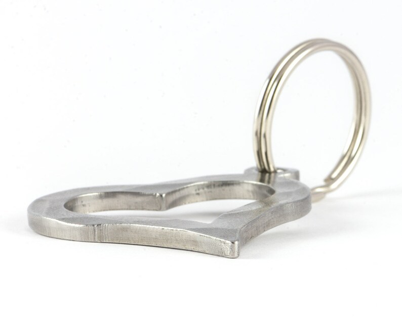 May include: A silver heart-shaped key chain with a double ring.