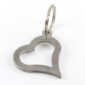 May include: A silver heart-shaped keychain with a silver key ring.