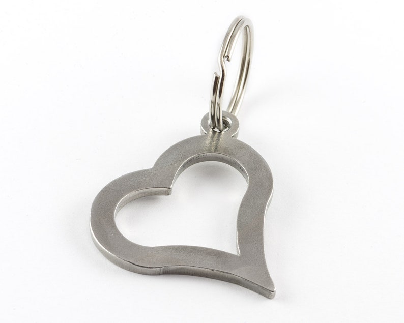 May include: A silver heart-shaped keychain with a silver key ring.