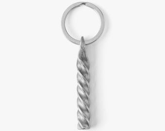 May include: A silver metal keychain featuring a twisted, horn-shaped pendant. The pendant has a spiral design and is attached to a circular key ring. The keychain is displayed against a white background.