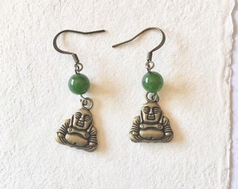 May include: A pair of gold-toned earrings with green jade beads and a small Buddha charm on each earring.
