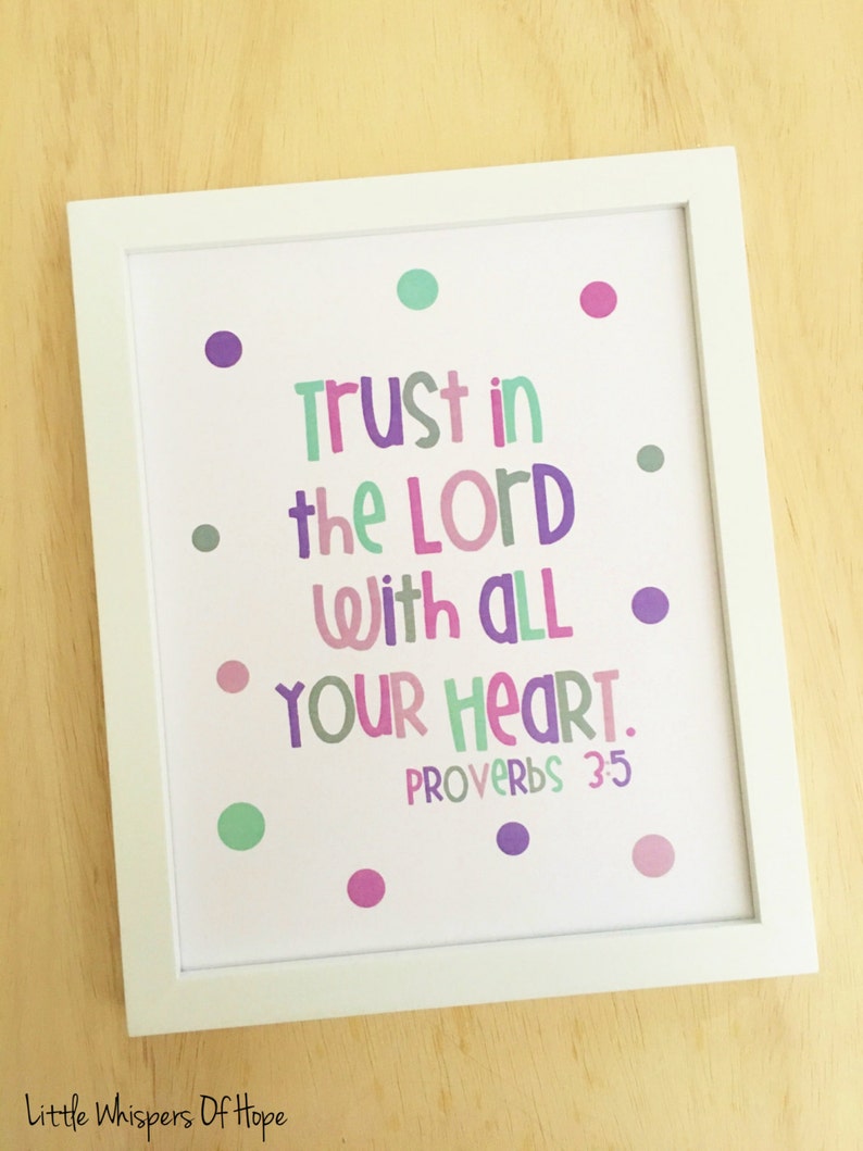 May include: A framed print with a white background and colorful polka dots. The print features the text "Trust in the Lord with all your heart. Proverbs 3:5" in a colorful, playful font.