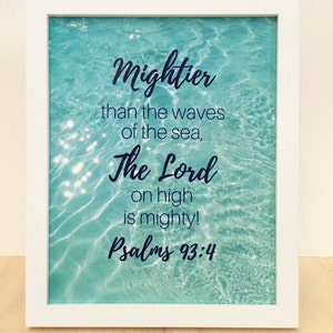May include: White framed print with a turquoise blue water background. The text reads "Mightier than the waves of the sea, The Lord on high is mighty! Psalms 93:4"