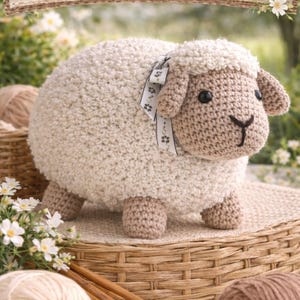 May include: A crochet pattern featuring a cream-coloured sheep with light brown face, legs, and ears, and a decorative ribbon. The sign above reads "CROCHET PATTERN". Yarn and crochet needles are in the foreground. The sheep is sitting on a woven basket.