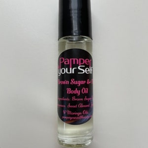 Może przedstawiać: Przezroczysta szklana butelka z rolką z czarną zakrętką i etykietą. Etykieta zawiera napis "Pamper your Self" w różowych i czarnych literach. Butelka zawiera olejek do ciała z brązowego cukru i fig. Składniki są wymienione na etykiecie: brązowy cukier, zapach, słodkie migdały i oleje z moringi.