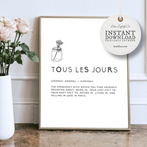 May include: Black and white printable art print with a simple line drawing of a jar with a flower inside. The text "TOUS LES JOURS" is written in a bold font below the image. The text "[FRENCH: ADVERB] I EVERYDAY" is written below the title. The text "THE FREQUENCY WITH WHICH YOU FIND YOURSELF DREAMING ABOUT; BEING IN. YOUR LAST VISIT TO. YOUR NEXT VISIT TO. EATING IN, LIVING IN. AND FALLING IN LOVE IN PARIS." is written below the text "[FRENCH: ADVERB] I EVERYDAY".