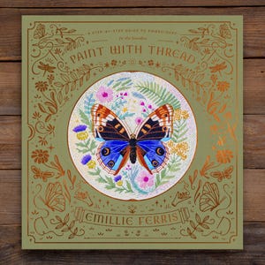 May include: A green book cover with gold lettering that reads "A Step-by-Step Guide to Embroidery in the Garden: Paint with Thread" and features a detailed illustration of a butterfly with colourful wings surrounded by flowers and leaves.