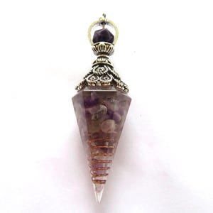 Könnte beinhalten: Ein Pendel mit einer facettierten Amethyst-Kristallspitze. Das Pendel hat eine silberfarbene Metallkappe und eine Kupferdrahtspirale um den Kristall. Der Kristall ist mit kleinen Amethyststeinen gefüllt.