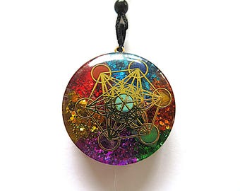 May include: A round, rainbow-colored pendant with a gold geometric design inside. The pendant is made of resin and has a black cord.