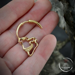 Op de afbeelding: Gouden schedelvormige oorring met een getextureerd ontwerp. De oorring is open en heeft een gebogen staaf die door het oor gaat.