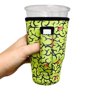 May include: Green and red brain-patterned neoprene cup holder with a black strap and a built-in finger loop. The holder is designed to fit a standard-sized cup.