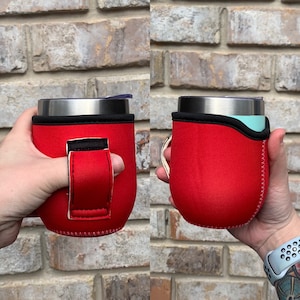Puede incluir: Portavasos aislante de neopreno rojo con asa negra y detalles de costura blancos. El portavasos está diseñado para adaptarse a un vaso de tamaño estándar.
