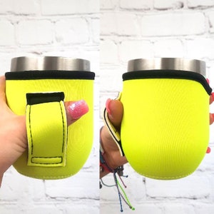 Puede incluir: Un portavasos de neopreno amarillo neón con ribete negro y un agujero para el pulgar para facilitar su transporte. El portavasos está diseñado para adaptarse a un vaso o vaso de tamaño estándar.