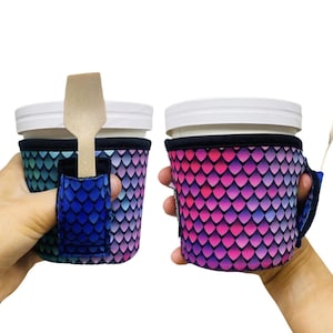 May include: Two insulated beverage holders with a colorful scale pattern. One holder has a wooden spoon attached to it.