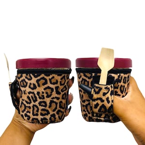 May include: Two leopard print insulated cups with lids. One cup has a wooden spoon in a pocket on the side.