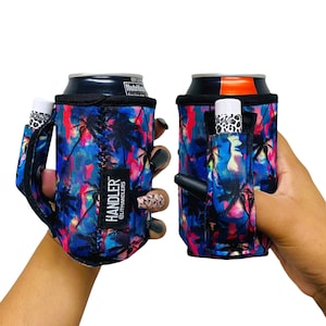 May include: A black and blue can holder with a tropical palm tree print. The holder has a built-in handle and a pocket for a small item, such as a lip balm. The text "HANDLER" and "@LITHANDLERS" is printed on the holder.