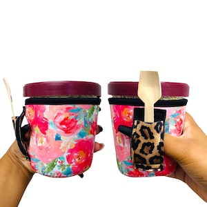 May include: Two pink floral insulated cups with lids and a wooden spoon attached to one cup with a leopard print strap.