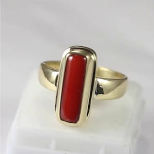 May include: A gold ring with a rectangular red coral gemstone set in a bezel setting.