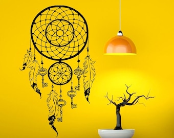 May include: Black and white dreamcatcher wall decal with feathers and keys. The decal is on a yellow wall with a hanging light fixture.