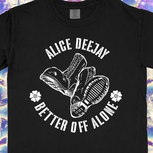 May include: Black t-shirt with the text "ALICE DEEJAY" above a graphic of two boots and the phrase "BETTER OFF ALONE". The shirt also has the text "PRE-ORDERS NOW OPEN" and "LINK IN BIO".