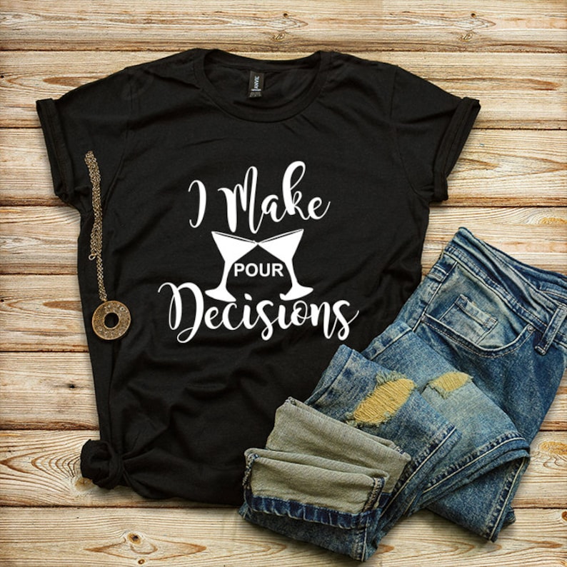 Puede incluir: Camiseta negra con texto blanco que dice "I Make Pour Decisions" y un gr&aacute;fico de dos copas de vino brindando.