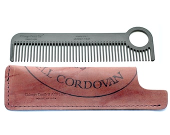 May include: A black metal comb with a round hole in the handle. The comb is in a brown leather case with the text "Shell Cordovan" and "Chicago Comb Co. x Ashland Made in USA".