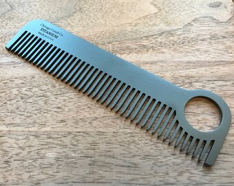 May include: A gray titanium comb with a round hole in the handle. The comb is made in the USA and has the text "Chicago Comb Co. TITANIUM Made in U.S.A." on the back.
